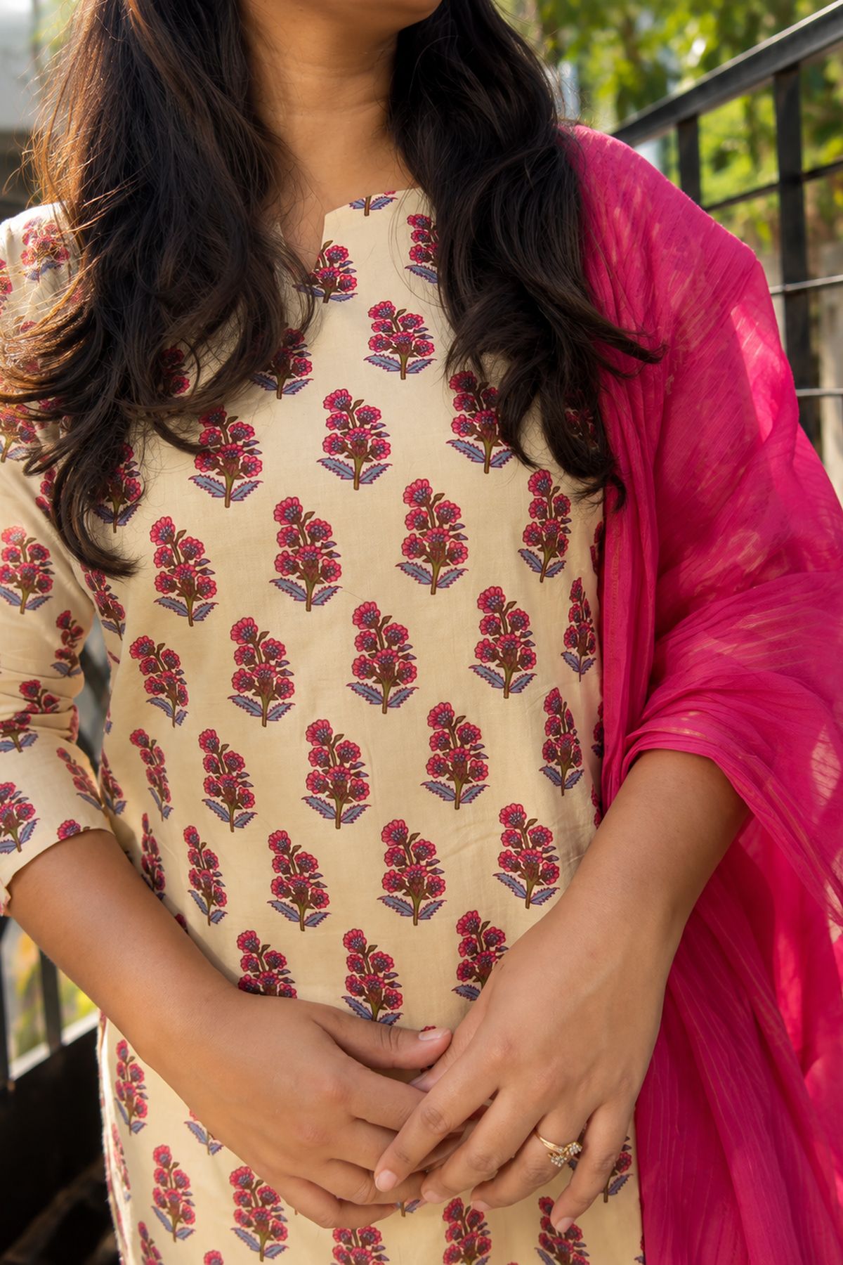Close view of the pink floral buti print and the notched neckline