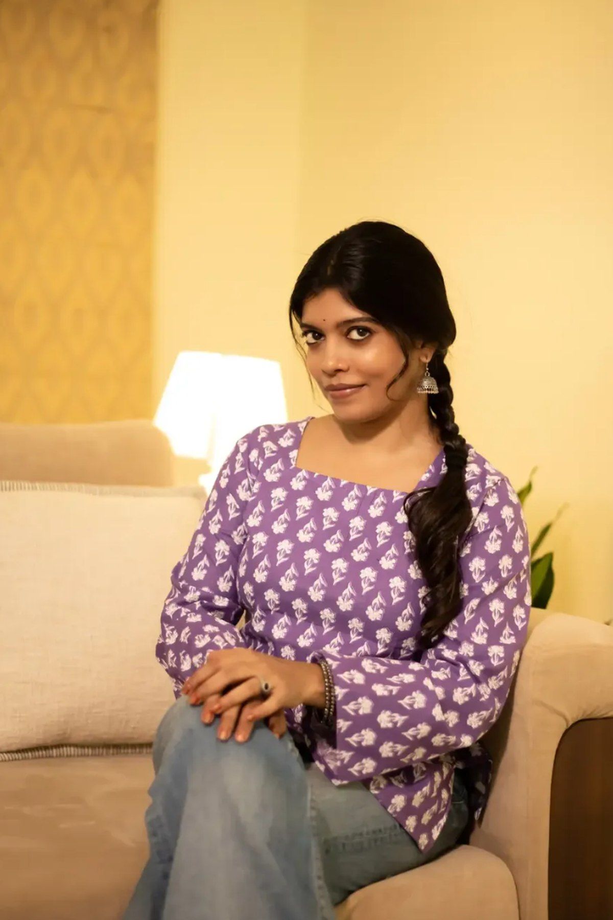 Seated view of the lilac buti top showing the square neck and full sleeves